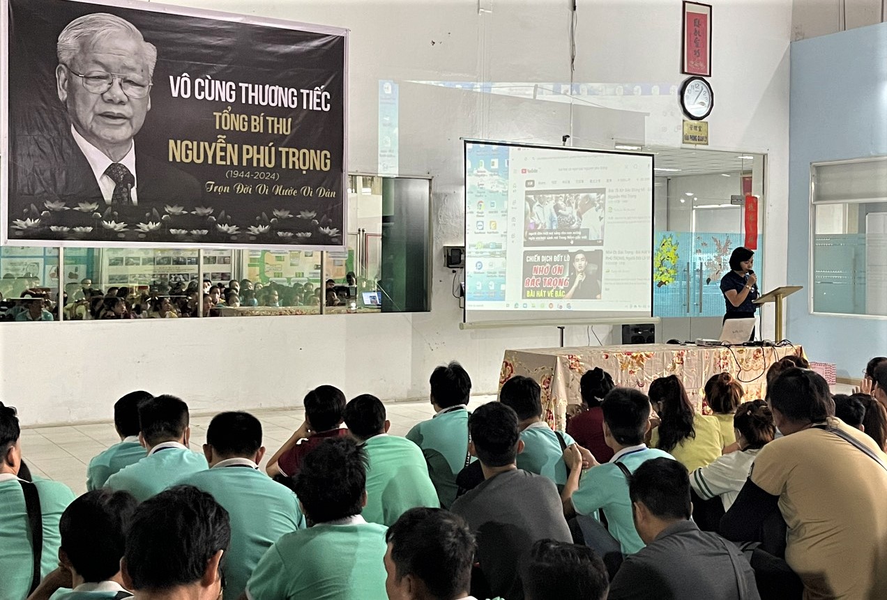 Hàng trăm công nhân Công ty TNHH cao su Phong Thái nghe Công đoàn cơ sở báo cáo những đóng góp to lớn của Tổng Bí thư Nguyễn Phú Trọng trước khi làm lễ tưởng niệm.